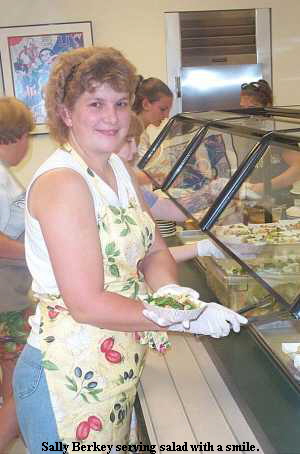 Sally Berkey serving salad with a smile.
