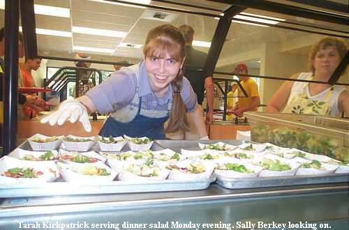 Tarah Kirkpatrick serving dinner salad Monday evening. Sally Berkey looking on.
